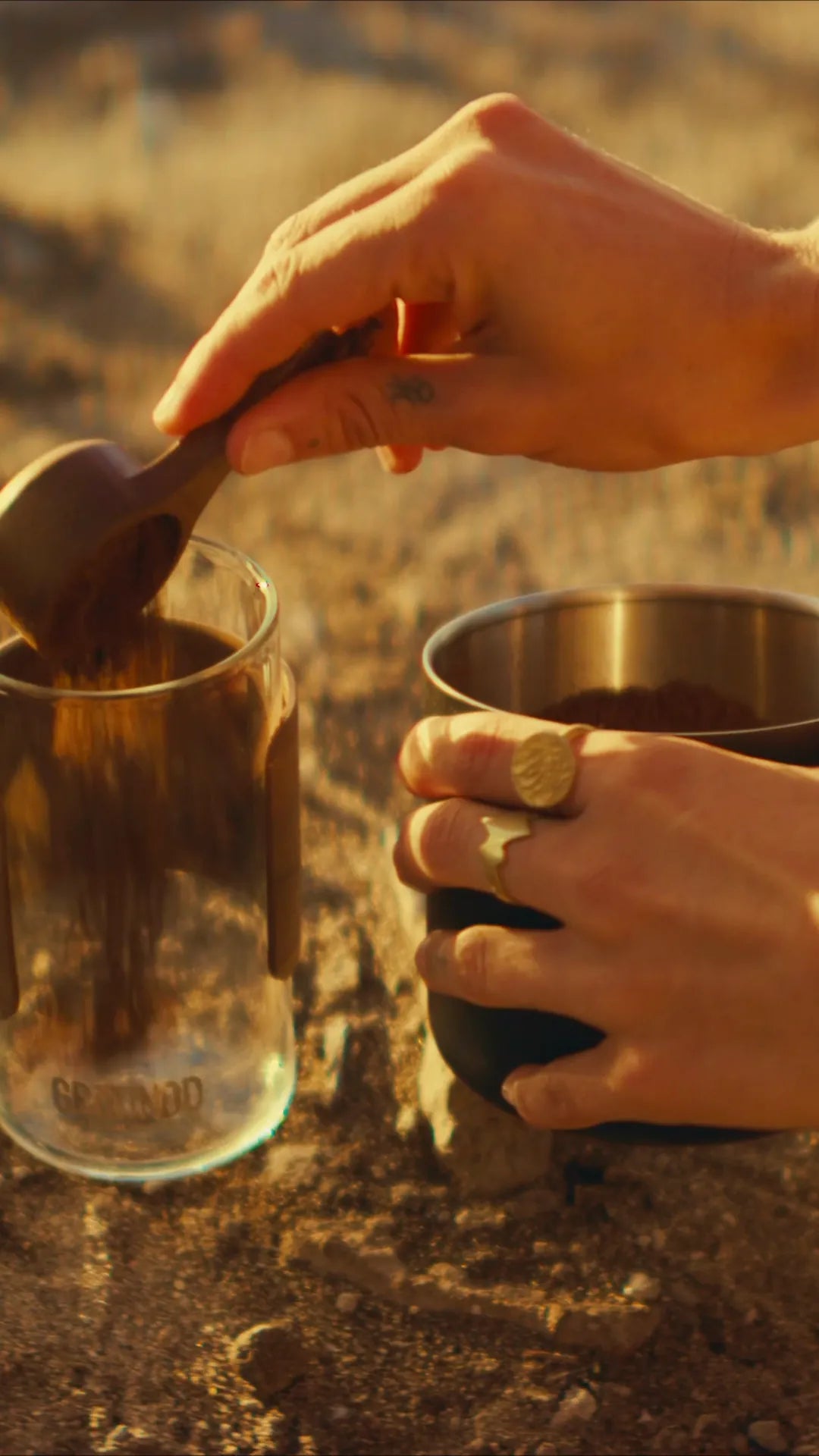 Spooning coffee grounds into a GROUNDD xpress outdoors