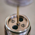 Close view of the adjustable brew plunger seated in the anti spill lid