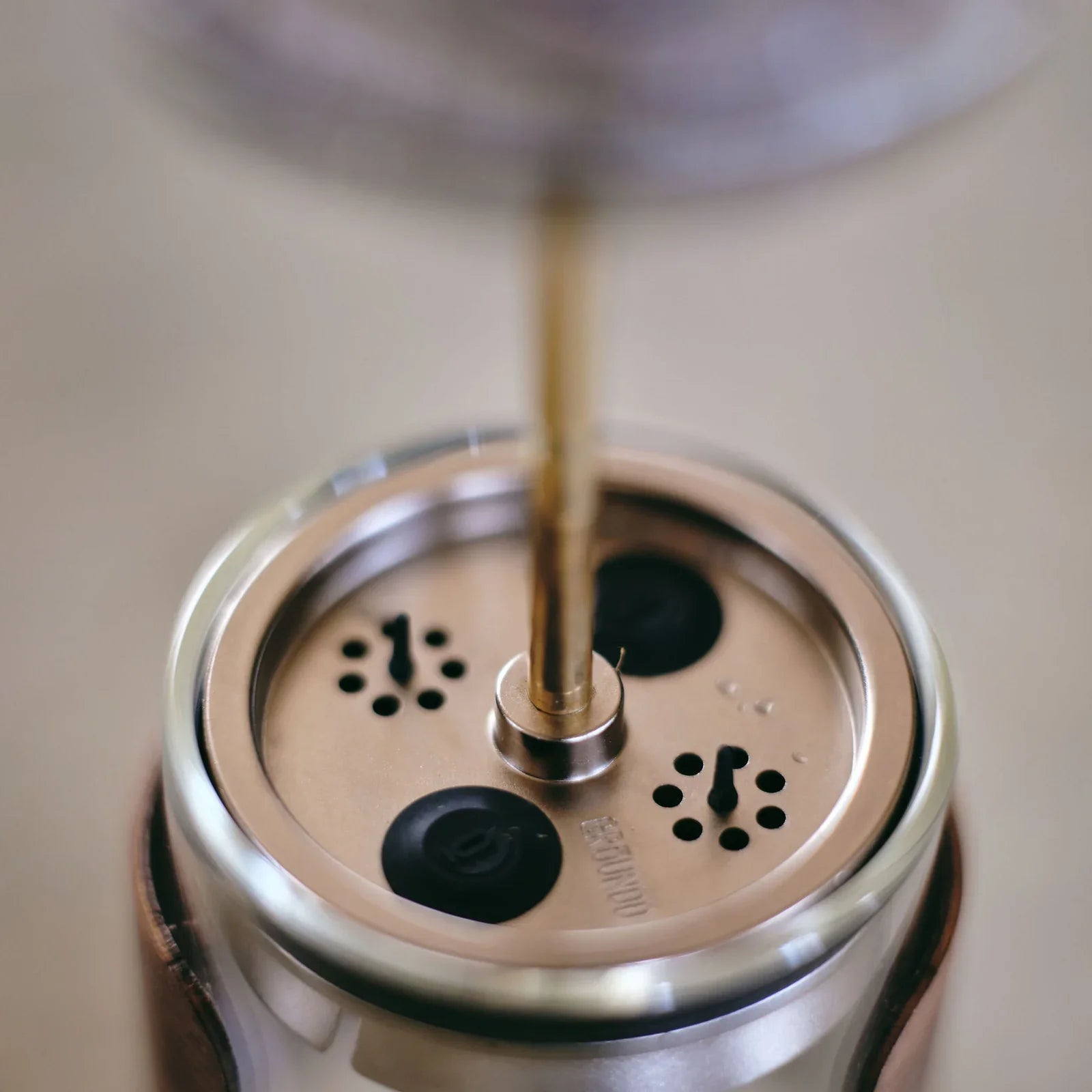 Close view of the adjustable brew plunger seated in the anti spill lid