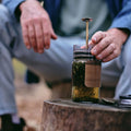 Green tea being plunged in the GROUNDD xpress on a tree stump